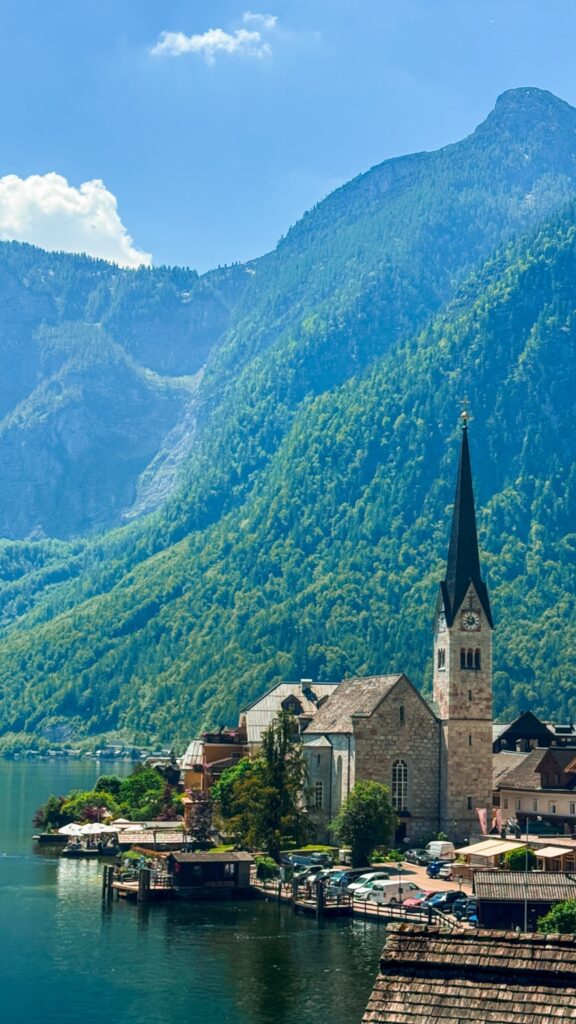 Hallstatt church and Lake Hallstatt surrounded by mountains in Austria